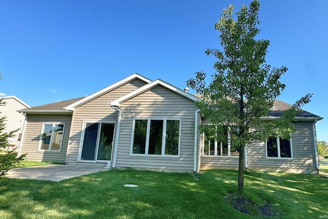 back of property with a patio area and a yard