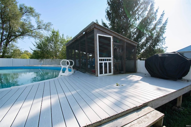 view of pool featuring a grill, a sunroom, and a wooden deck