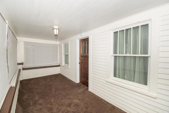 unfurnished living room featuring carpet floors and ornamental molding