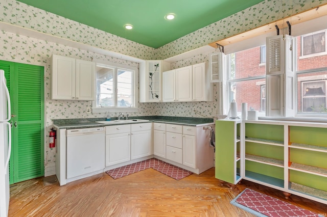 kitchen featuring white cabinets, dishwasher, and sink