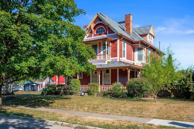 victorian house with a front lawn and a porch