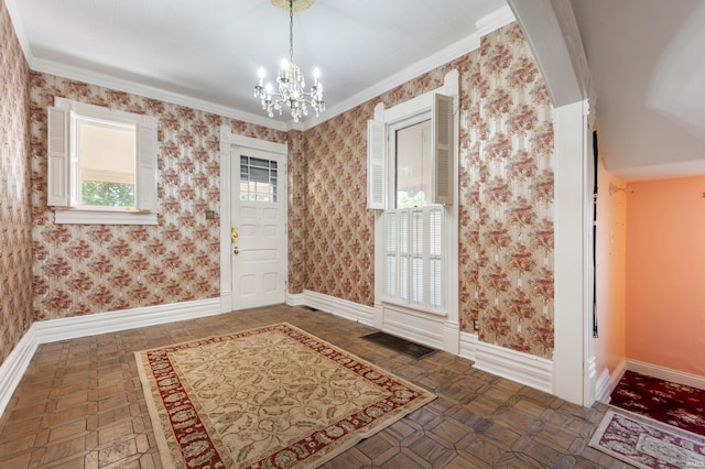 foyer with crown molding and a chandelier