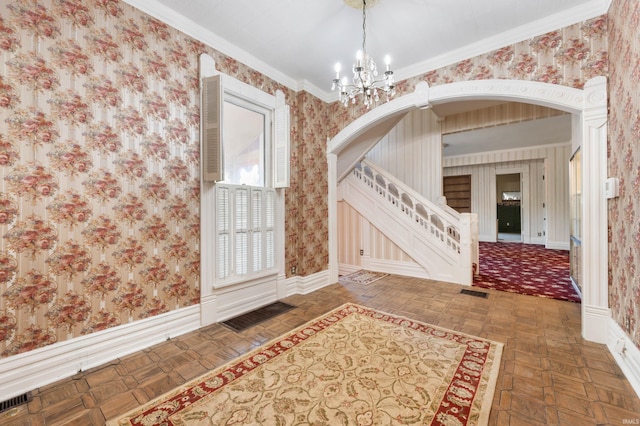 entrance foyer featuring a chandelier, dark parquet floors, and crown molding