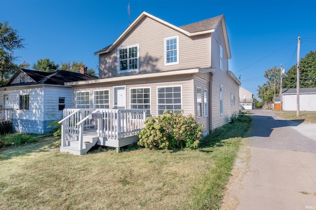 rear view of property featuring a deck and a yard