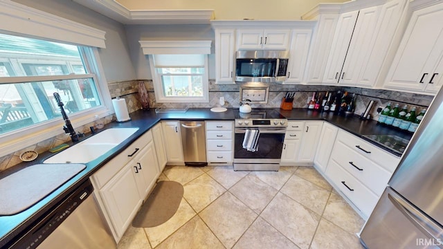 10922 N Lower Lakeshore Dr, Monticello, IN 47960 - kitchen featuring a healthy amount of sunlight, a sink, dark countertops, and appliances with stainless steel finishes