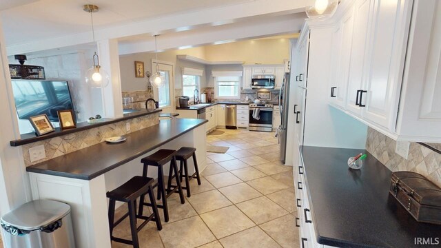 kitchen with vaulted ceiling with beams, white cabinets, pendant lighting, sink, and a kitchen breakfast bar