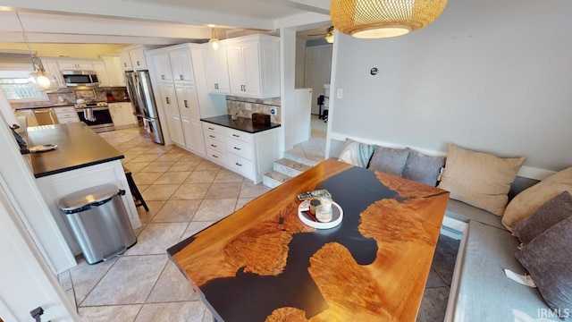 10922 N Lower Lakeshore Dr, Monticello, IN 47960 - kitchen with tasteful backsplash, light tile patterned floors, stainless steel appliances, dark countertops, and a ceiling fan