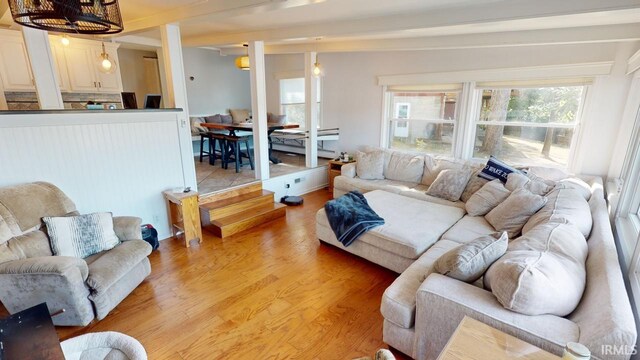 living room featuring light wood-type flooring and beam ceiling