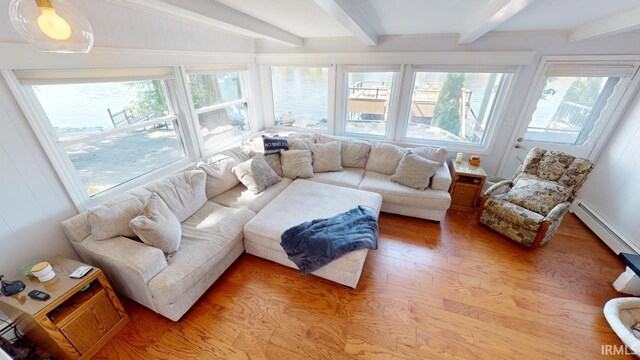 living room featuring beam ceiling, baseboard heating, plenty of natural light, and light hardwood / wood-style floors