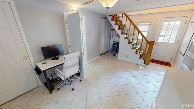 home office with light tile patterned floors and ceiling fan