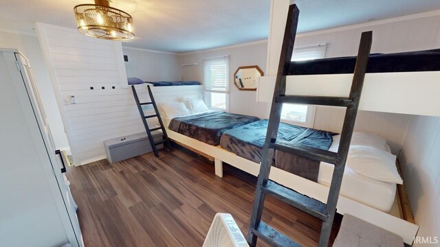 bedroom with crown molding, dark wood-type flooring, and a notable chandelier