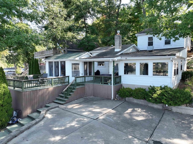 10922 N Lower Lakeshore Dr, Monticello, IN 47960 - back of property featuring a patio area, a chimney, a shingled roof, and a deck