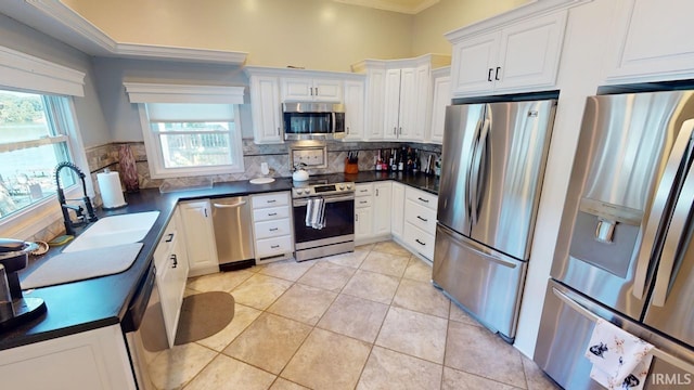 10922 N Lower Lakeshore Dr, Monticello, IN 47960 - kitchen featuring a sink, dark countertops, appliances with stainless steel finishes, and white cabinetry