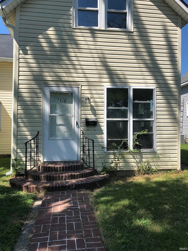 property entrance with a lawn