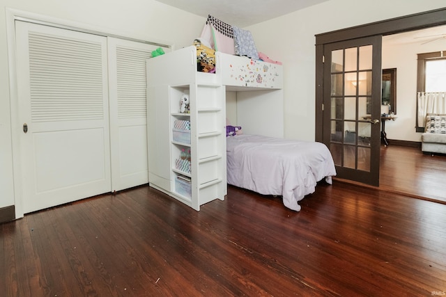 bedroom featuring french doors, a closet, and dark wood-type flooring