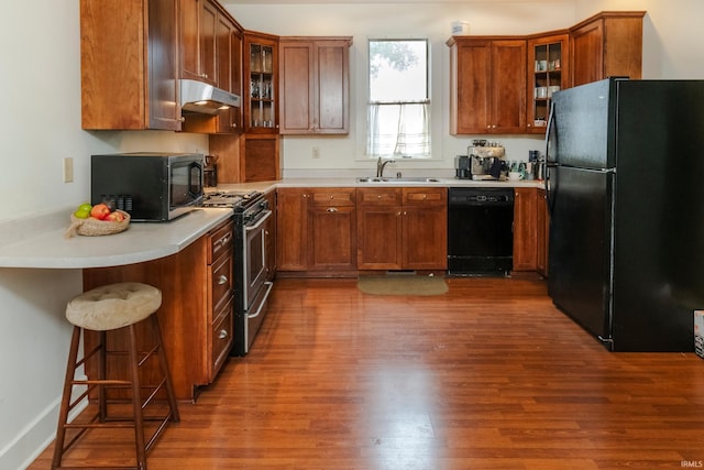 kitchen featuring black appliances, sink, and wood-type flooring