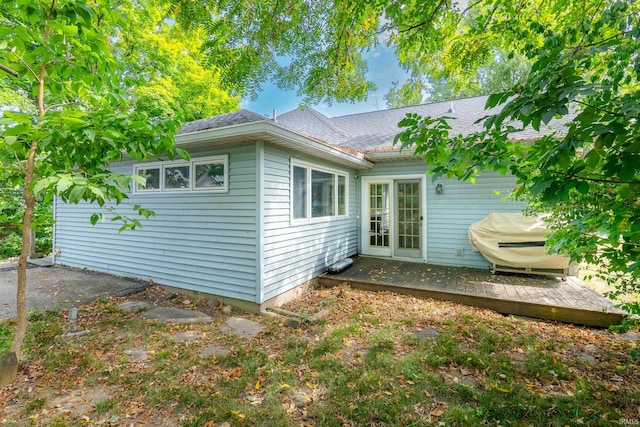 view of property exterior featuring a wooden deck and french doors