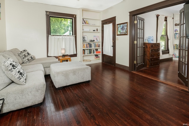 living room with french doors, hardwood / wood-style floors, and built in shelves