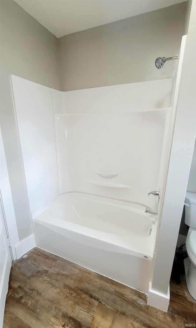 bathroom featuring wood-type flooring, toilet, and shower / bathing tub combination