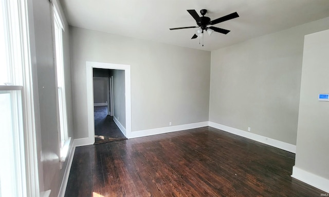 empty room with ceiling fan and dark hardwood / wood-style flooring