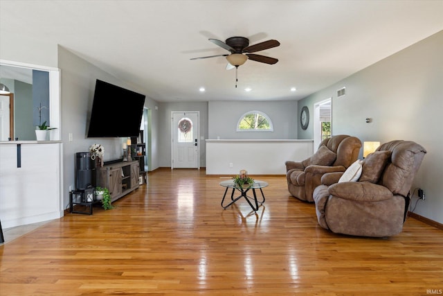 living room with light hardwood / wood-style flooring and ceiling fan