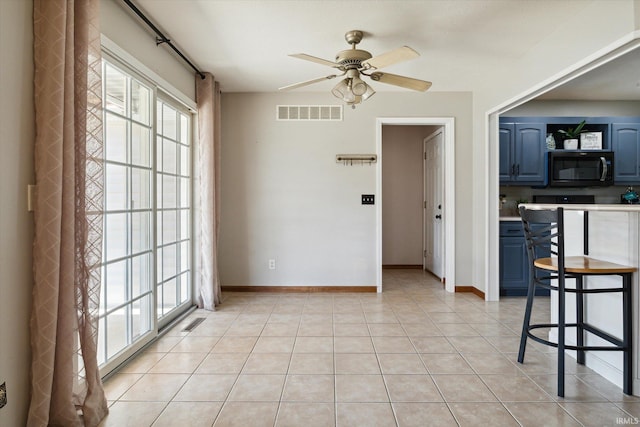 interior space with light tile patterned floors and ceiling fan