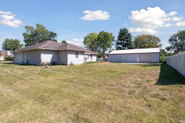 view of yard featuring a garage and an outbuilding