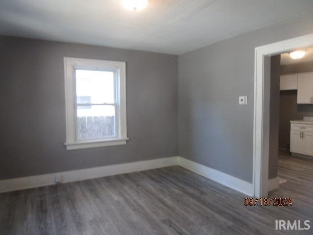 empty room with dark hardwood / wood-style flooring