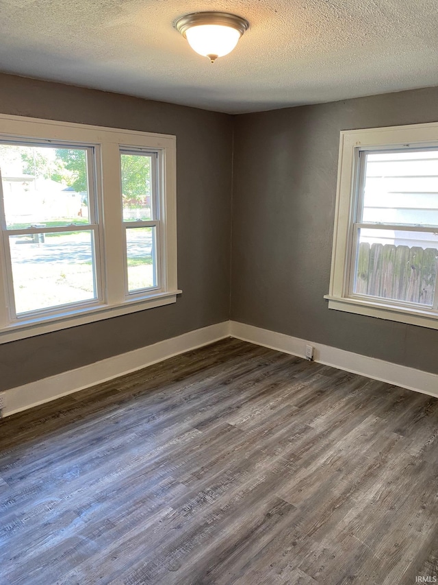 1243 Portage Ave, South Bend, IN 46616 - spare room featuring dark wood-type flooring, a textured ceiling, and baseboards