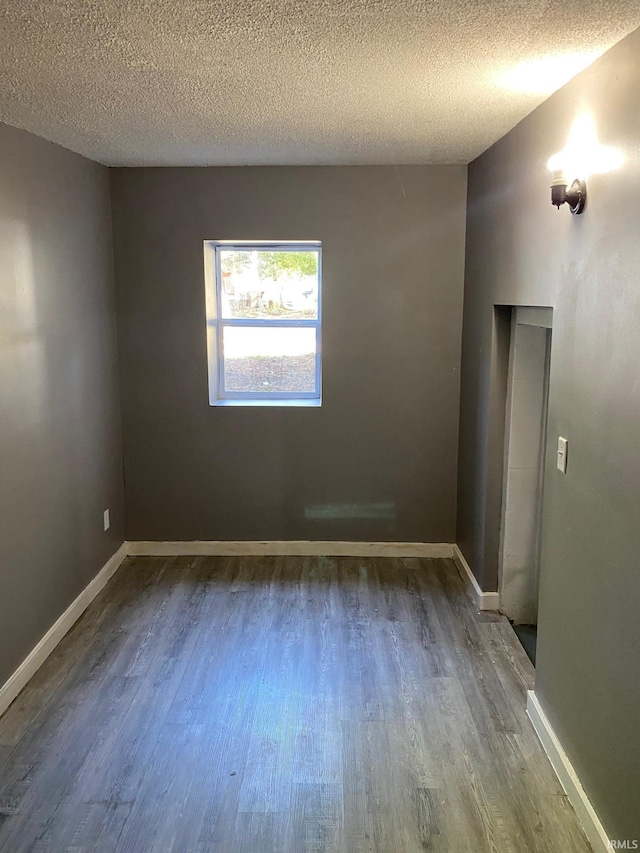 1243 Portage Ave, South Bend, IN 46616 - spare room featuring dark wood-type flooring, a textured ceiling, and baseboards