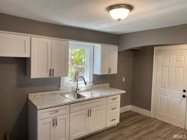 kitchen with a textured ceiling, dark hardwood / wood-style floors, sink, and white cabinetry