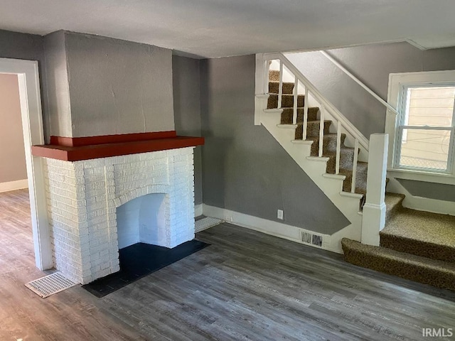 1243 Portage Ave, South Bend, IN 46616 - stairway with visible vents, baseboards, wood finished floors, and a fireplace