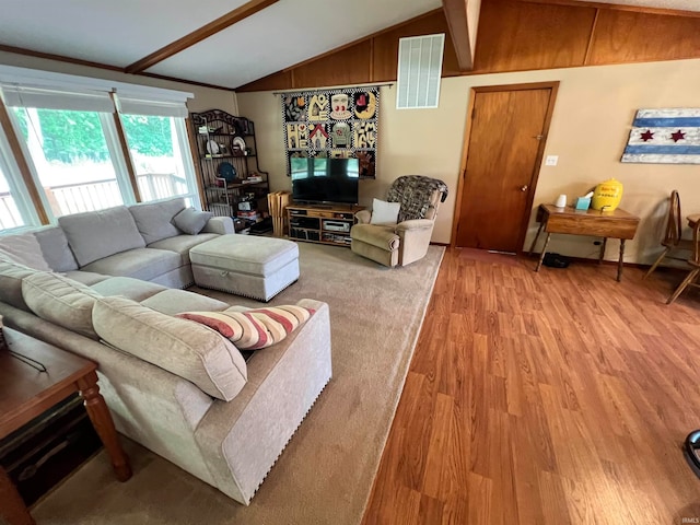 living room featuring vaulted ceiling with beams, wood walls, and hardwood / wood-style floors