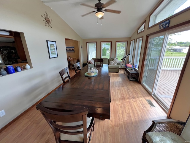 dining space with ceiling fan, light wood-type flooring, and high vaulted ceiling