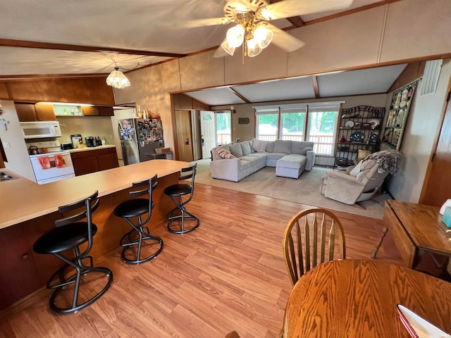 living room with wooden walls, vaulted ceiling, ceiling fan, and light hardwood / wood-style flooring