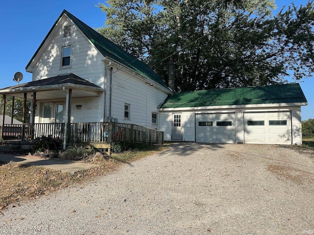 view of front of house featuring a garage, an outdoor structure, and covered porch