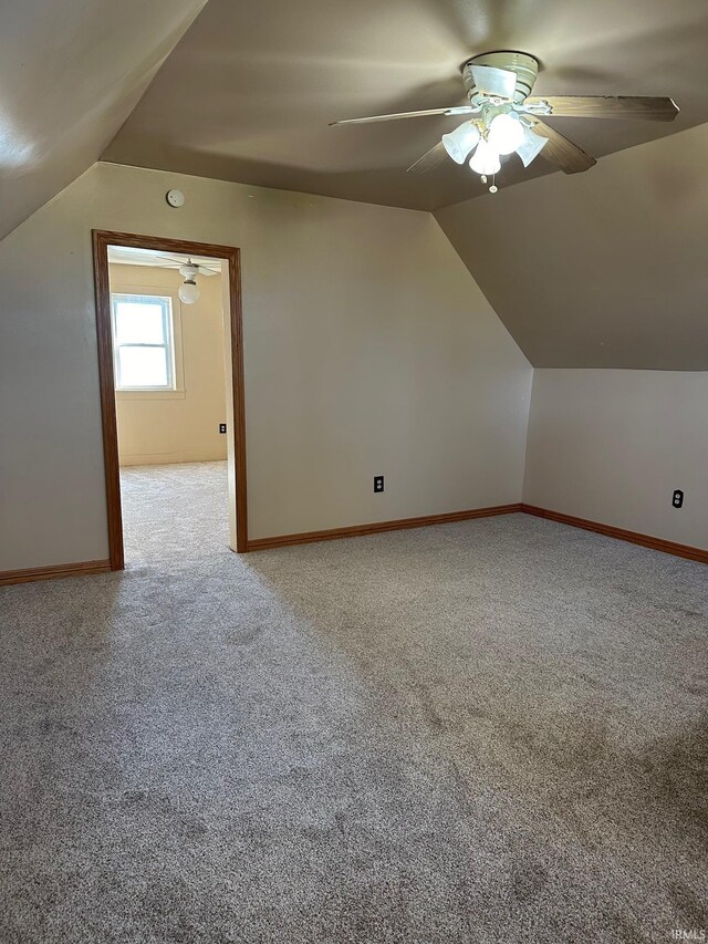 additional living space featuring vaulted ceiling, ceiling fan, and light colored carpet