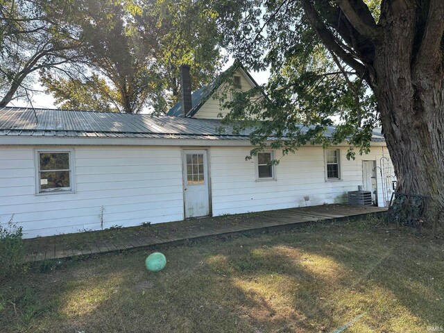 view of side of property with a yard and central air condition unit