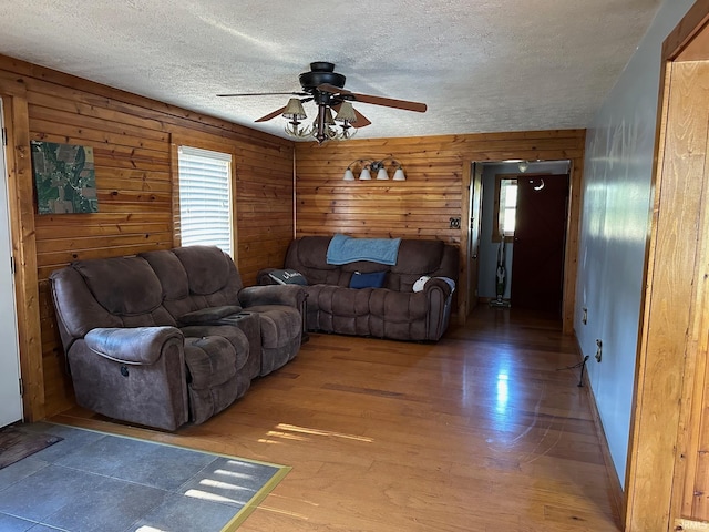 living room featuring wood-type flooring, a textured ceiling, ceiling fan, and a healthy amount of sunlight