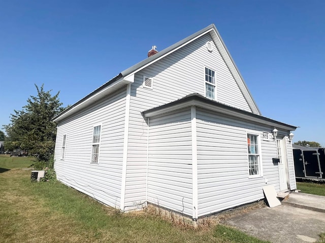 view of side of home featuring a lawn and central air condition unit