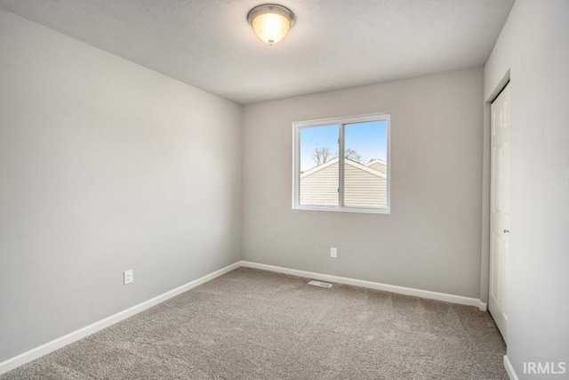 spare room featuring a textured ceiling and carpet floors