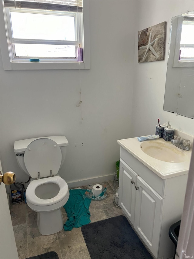 bathroom featuring vanity, toilet, and a wealth of natural light