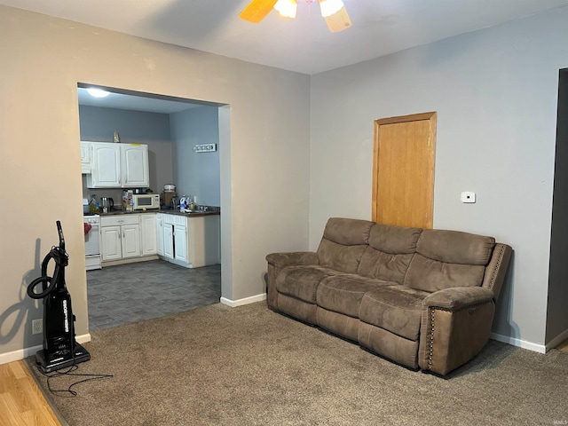 living room featuring dark carpet and ceiling fan