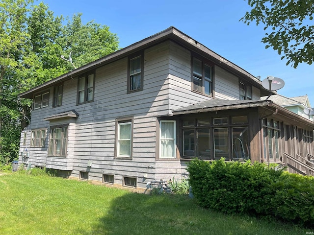 rear view of property with a yard and a sunroom