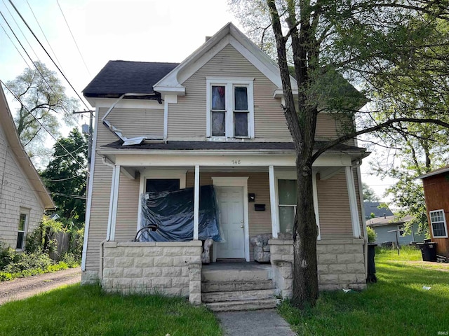 view of front of property with a porch and a front lawn