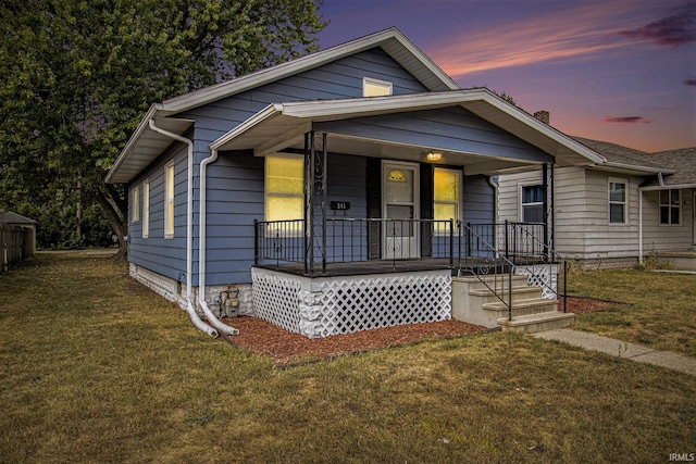 bungalow-style home featuring a porch and a yard