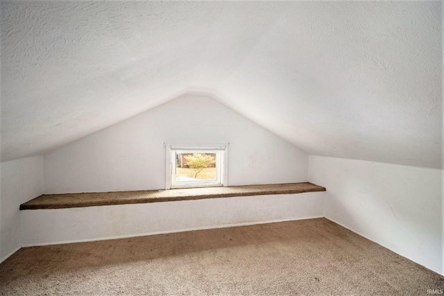 bonus room featuring carpet floors, a textured ceiling, and lofted ceiling