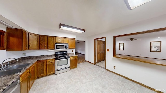 kitchen with appliances with stainless steel finishes, sink, and ceiling fan