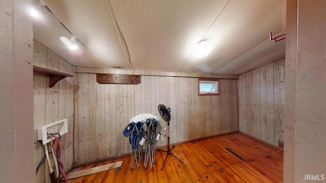 basement with wooden walls and light hardwood / wood-style floors