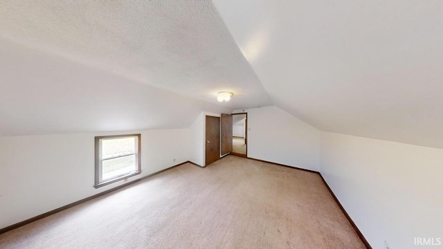 bonus room featuring light carpet, a textured ceiling, and lofted ceiling